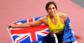 Madison de Rozario on the Olympic track with an Australian flag draped around her shoulders