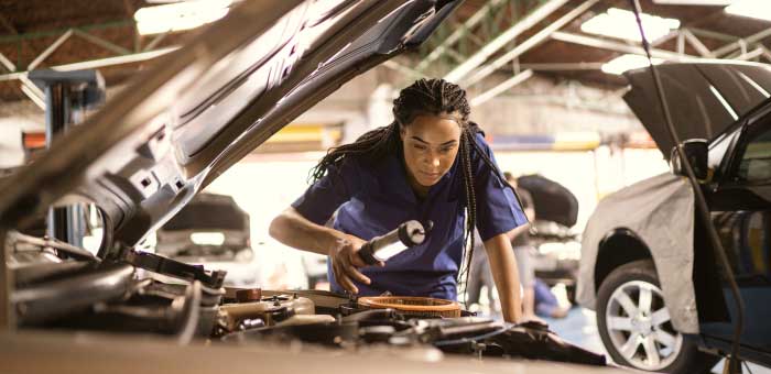 Vehicle service technician inspecting car motor