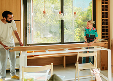 A couple lifting a wooden beam