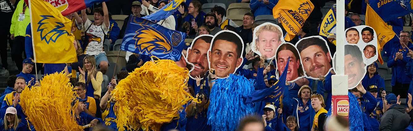 West Coast Eagle fans holding images of West Caost Eagles players and team flags