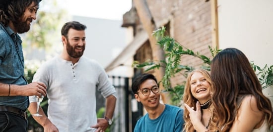 A woman bakes in a kitchen, leaving the oven door open to let heat out