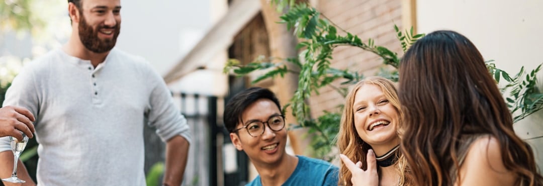 A diverse group of people smile as they are engaged in conversation
