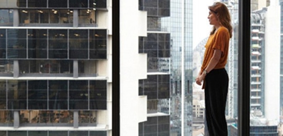 A woman looking out the window in an office building