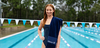 Mollie in front of a pool with an Allianz-branded towel