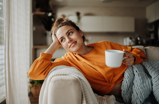 A woman relaxing on her couch at home.