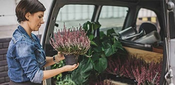 A woman with flowers in the boot of her car