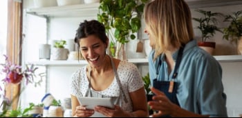 Two women talking and working
