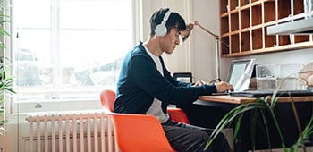 Man sitting at a desk working on a laptop