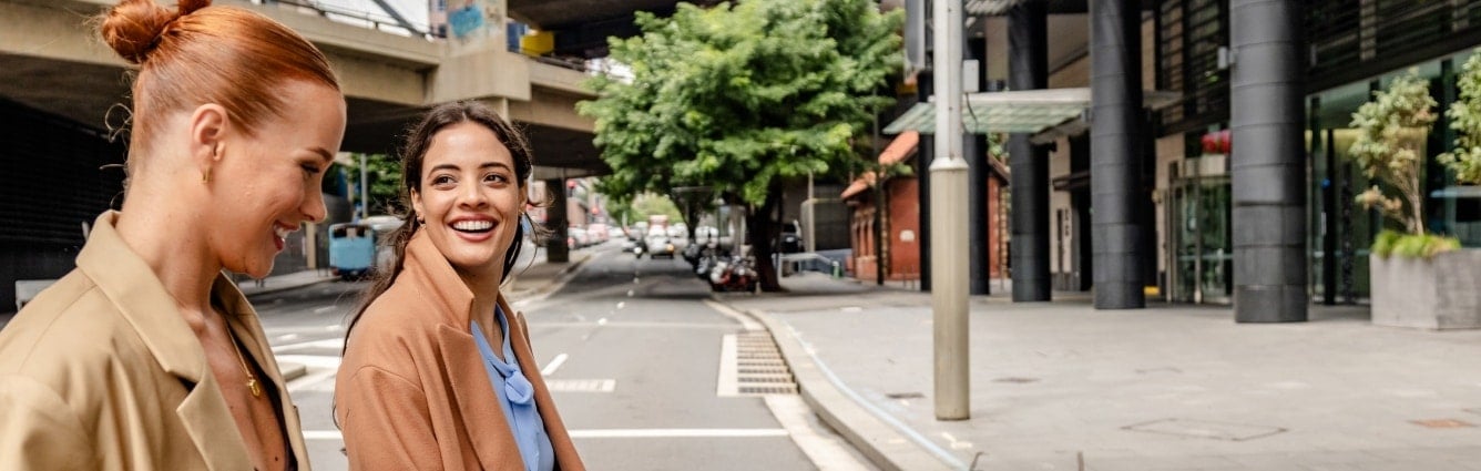 Two colleagues walking through the city with coffee