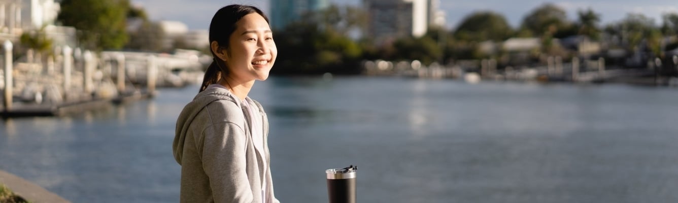 A happy woman smiles as she walks by the water
