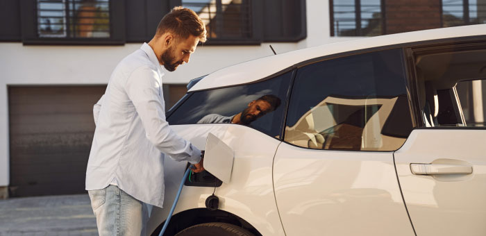 Person charging electric vehicle