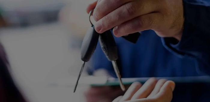 Person handing over keys to another person