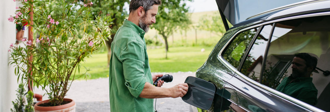 Male charging an electric vehicle from home