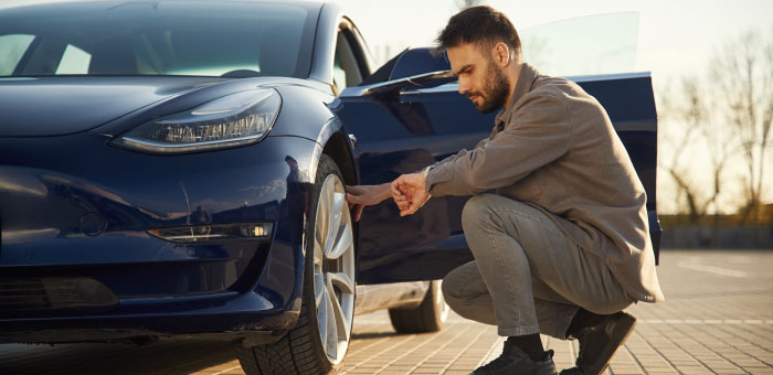 Male changing tyre on an electric vehicle