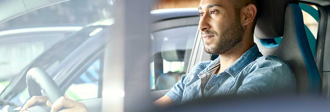 Man sitting in driver's seat of electric vehicle