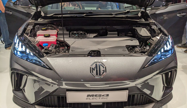 Front view of MG4 parked at an electric car show in Sydney, with its lights on and hood opened.