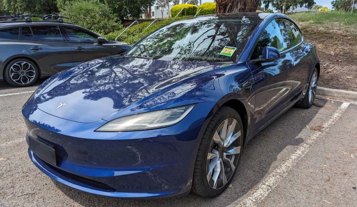 Side view of a 2024 Tesla Model 3 in a car park.