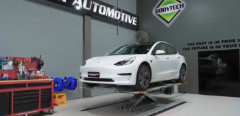 A white Tesla getting repaired