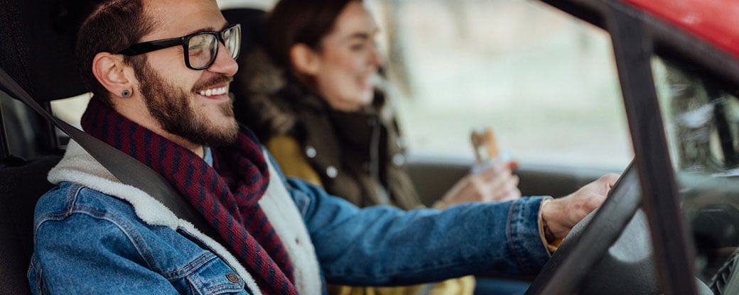 A driver enjoying a safe drive with his passenger.