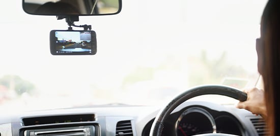 A drivers focuses on the road ahead while their dash cam records their drive.