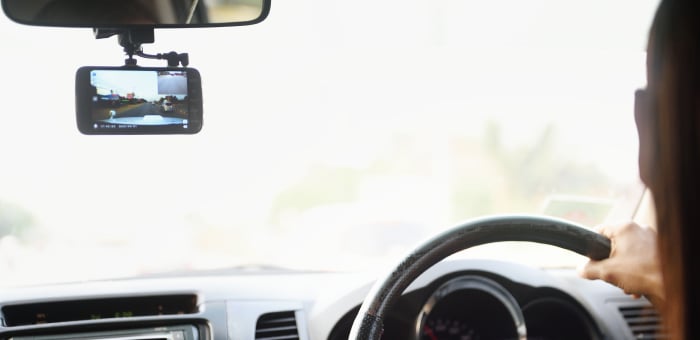 A drivers focuses on the road ahead while their dash cam records their drive.