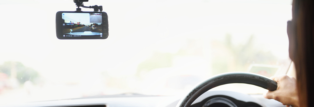 A drivers focuses on the road ahead while their dash cam records their drive.