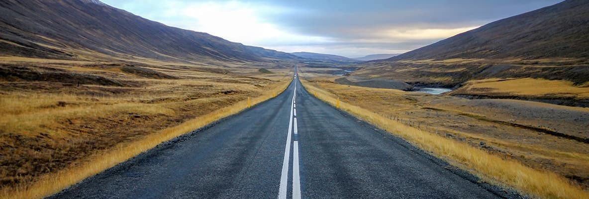 An open road with hills on either side