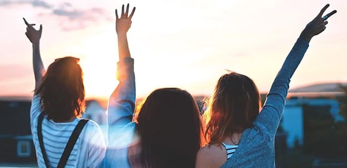 Group of friends looking out to a sunrise about to embark on a roadtrip