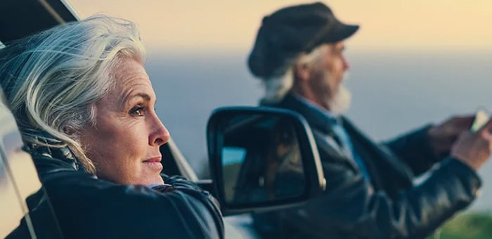 An older couple looking out of a car at the horizon