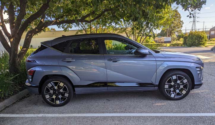 Side view of a 2024 Hyundai Kona Electric in a car park.