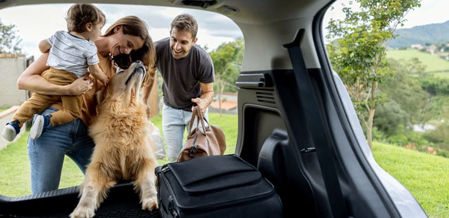 A young family packing the car and getting ready for a road trip.