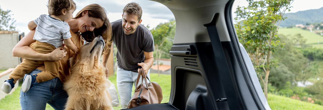 A young family packing the car and getting ready for a road trip.