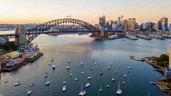 An aerial view of the Sydney Harbour Bridge with boats in the foreground.