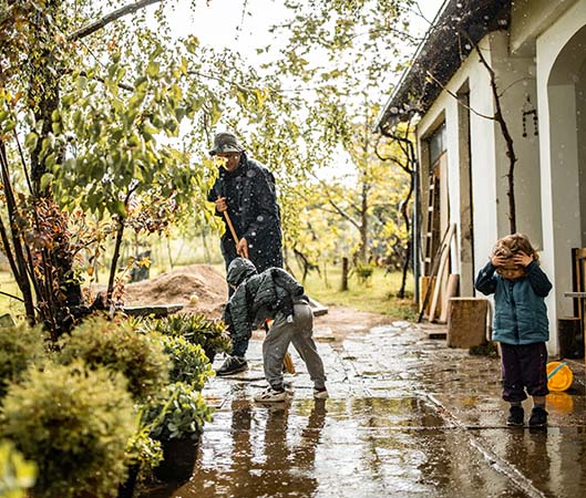 man and children cleaning up in the rain