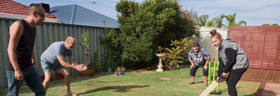 Image of people playing cricket in the backyard