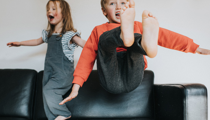 Children jumping on the sofa.