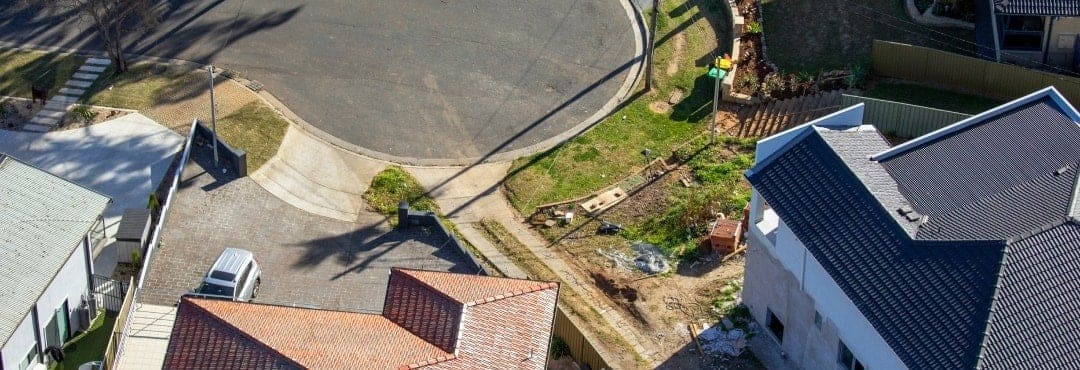 An aerial view of a car parked outside a house.
