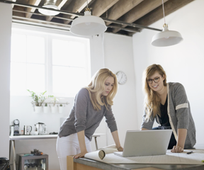 Two women lookinf at a laptop screen