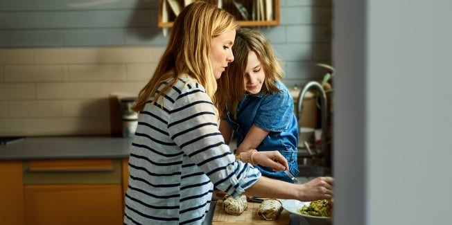 A mother and child sitting in a kitchen together