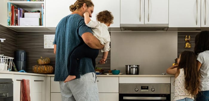 A young family in their kitchen at home.