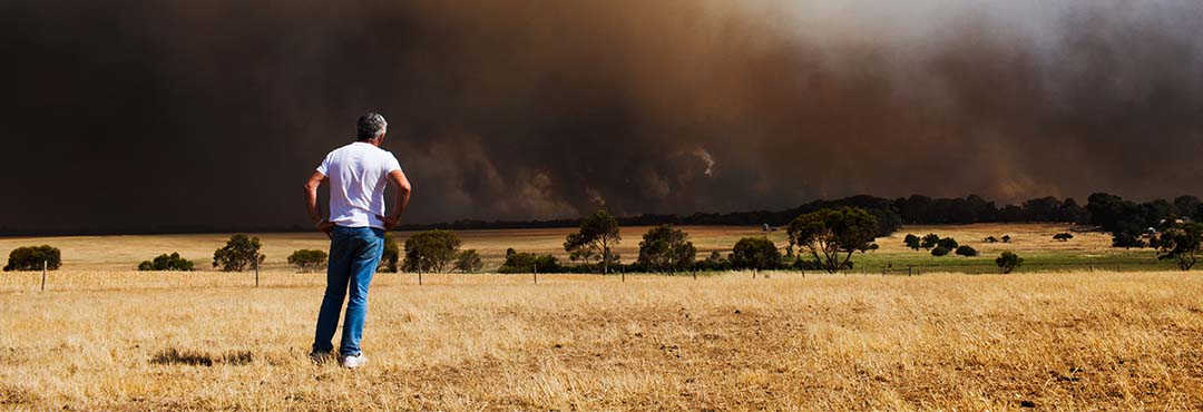 man watching thick bushfire smoke in the distance