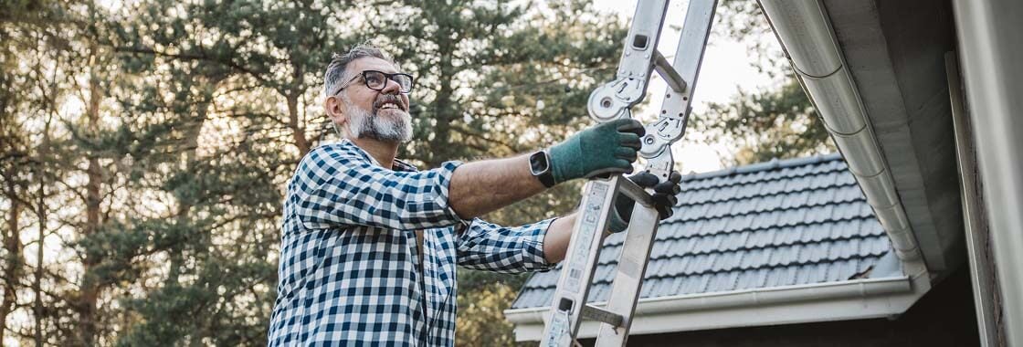 A homeowner safely checking the gutter