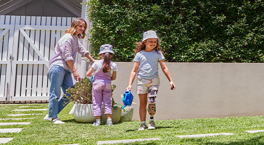 A mum outside in the garden with two kids