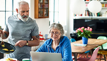 An older couple looking at a laptop