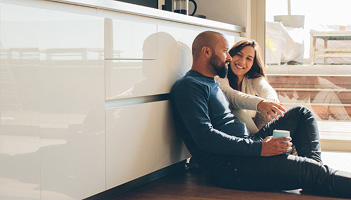 A couple sitting on the floor chatting to one another