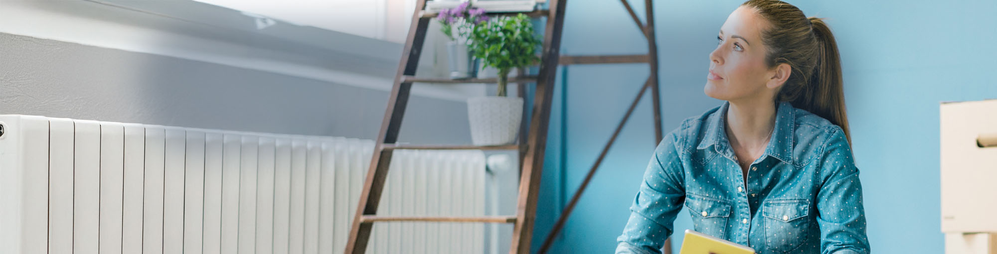 A lady sitting on the floor next to a ladder