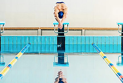 A swimmer dives into a pool