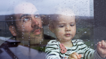 Dad and daughter looking out of a rainy window Dad and daughter looking out of a rainy window