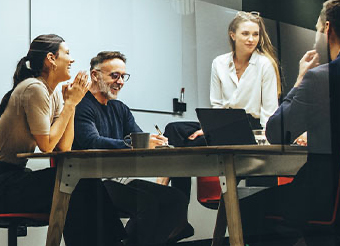 Workers in discussion around a desk