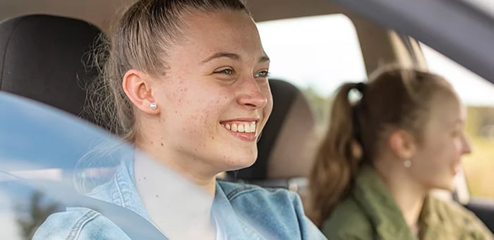Two young women driving a car